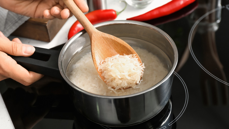 stirring rice with wooden spoon