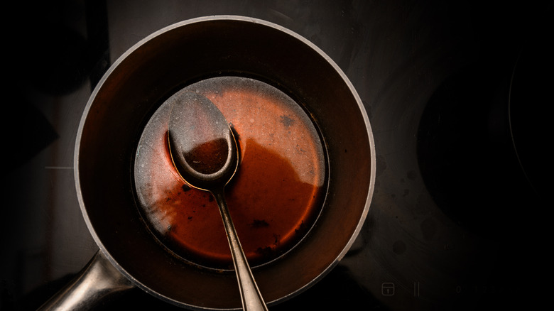 Beef stock in pot with metal spoon