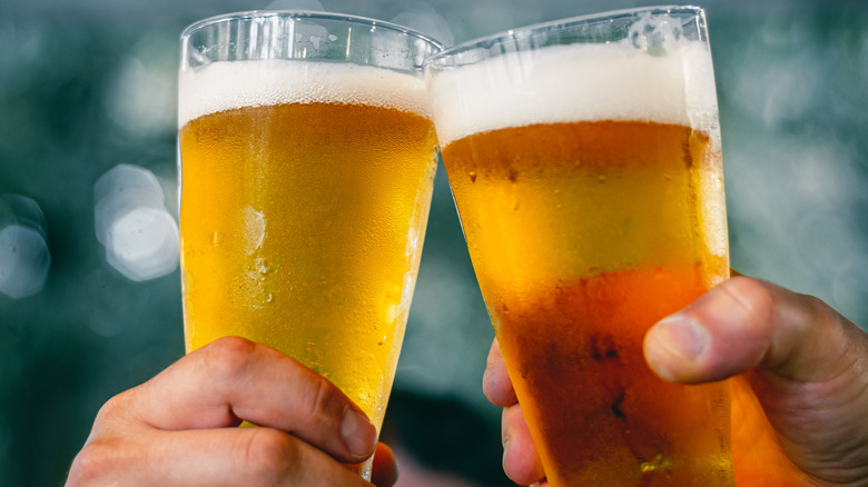 Two people toasting with beer