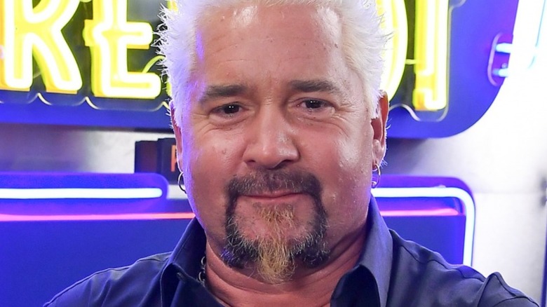 Guy Fieri in front of neon sign