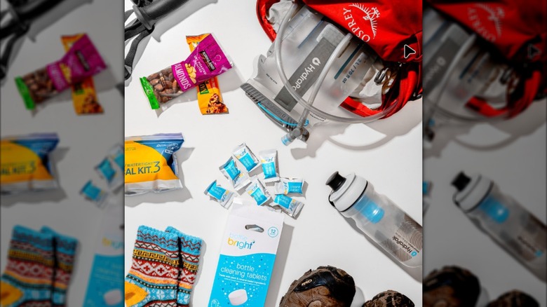 Bottle Bright tablets surrounded by hiking and Hydrapak gear