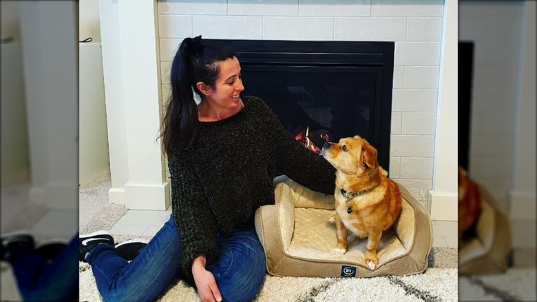 Heather saffer and  dog in front of fireplace