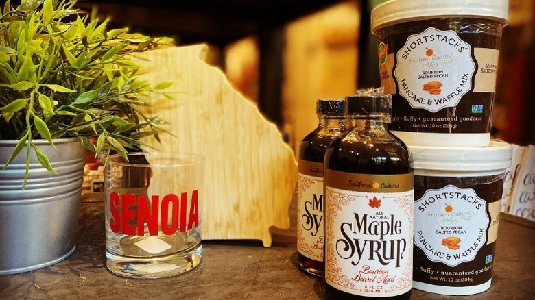 Maple syrup with tubs of pancake and waffle mix