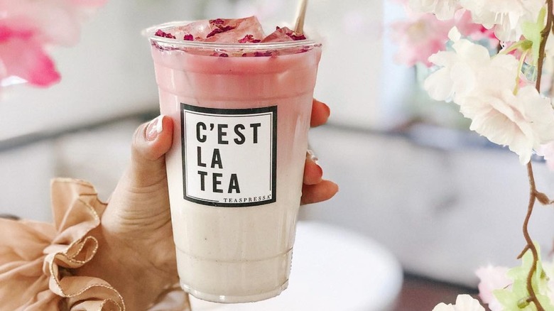 woman holding pink Teaspressa tea drink