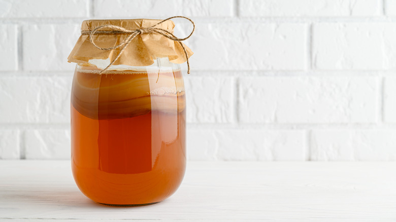 homemade jar of kombucha with lid cover and straw tie