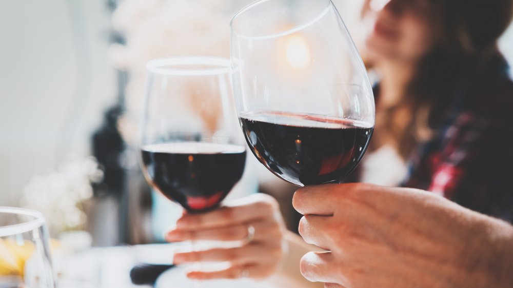 Two people cheers with glasses of wine