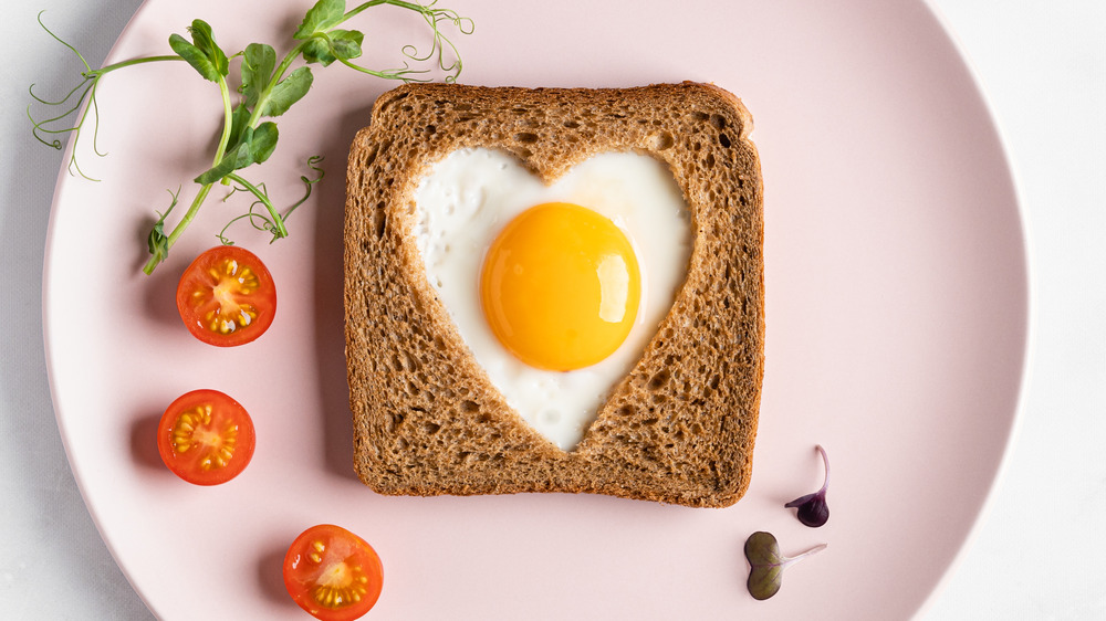 Heart-shaped cooked egg on slice of toast