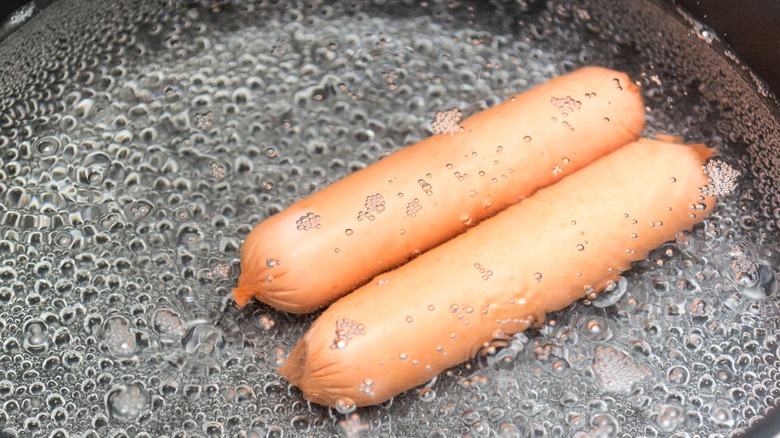 simmering hot dogs in water