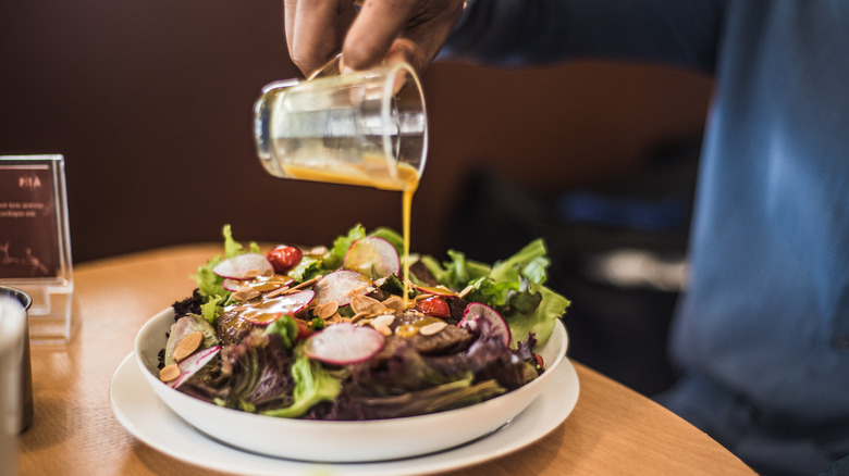 pouring dressing on salad