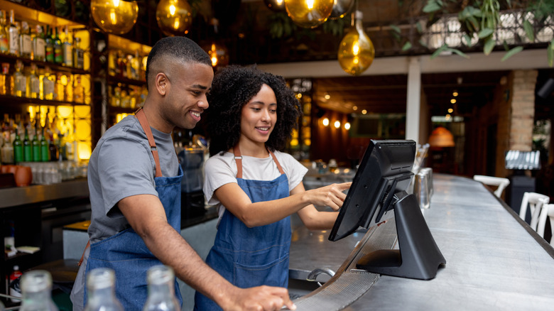 Two bartenders entering an order in the POS system