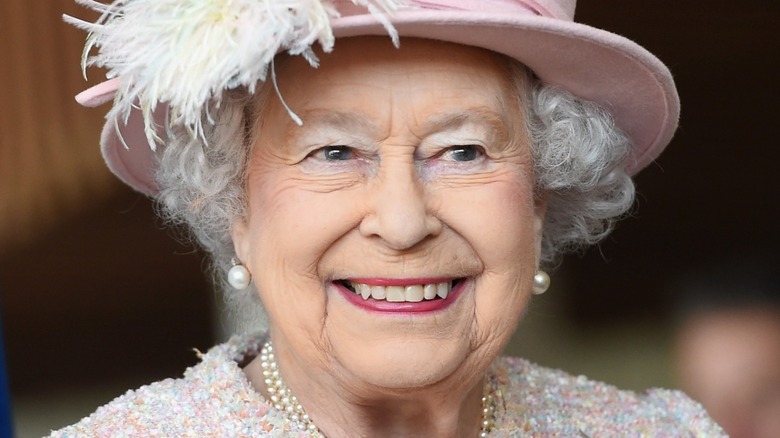 Queen Elizabeth with wide smile and pearl earrings