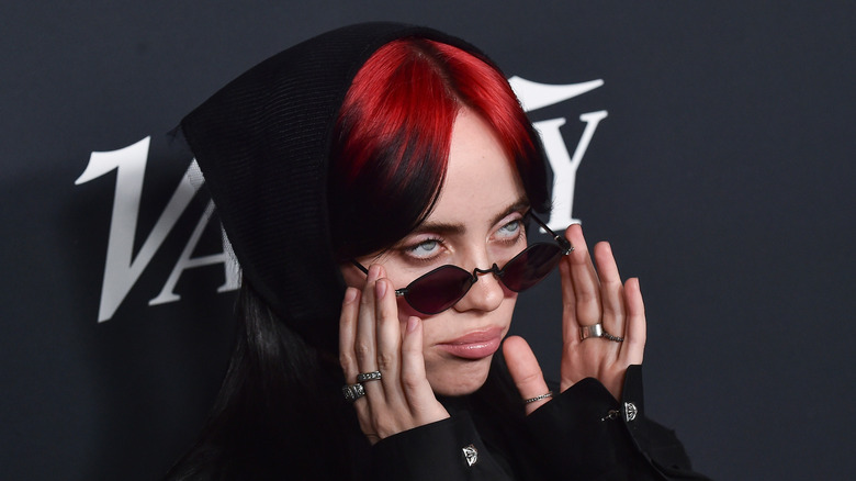 Billie Eilish peering over sunglasses