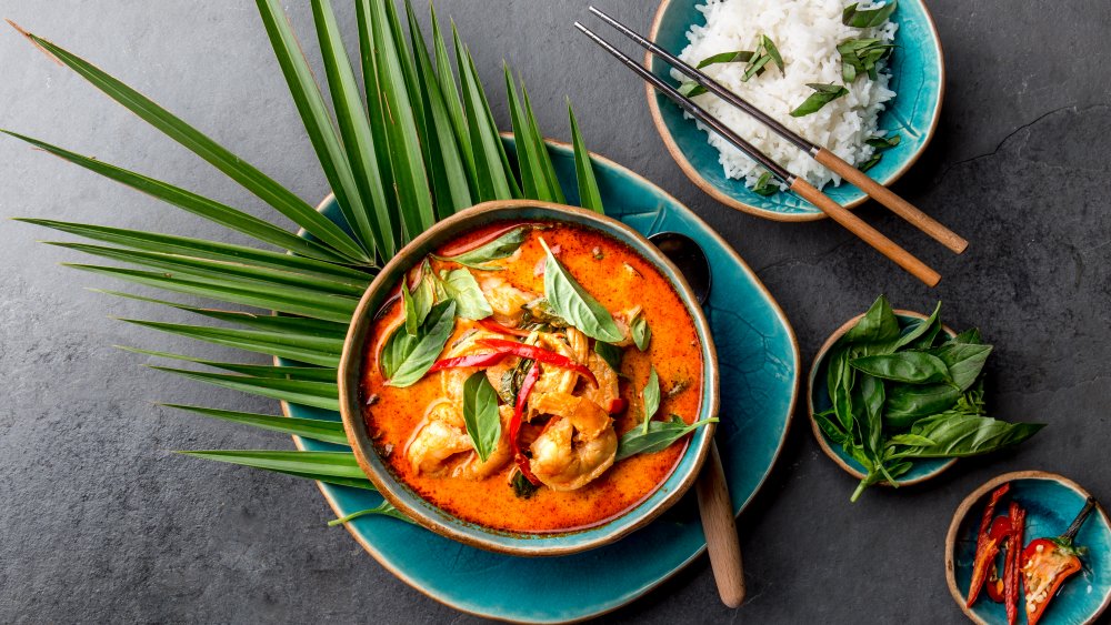 Thai red shrimp curry with a plate of cooked white rice on the side