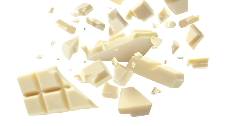 White chocolate bar shattered into pieces over white background