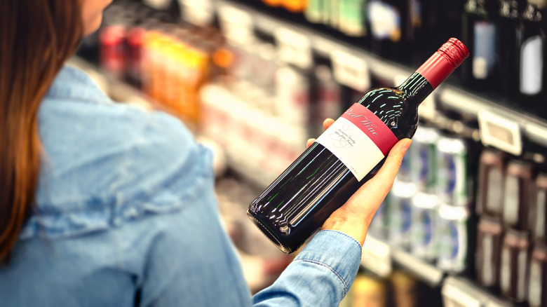 Woman looking at wine at store 