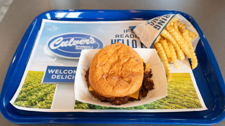 Culver's burger and French fries sitting on blue tray in restaurant