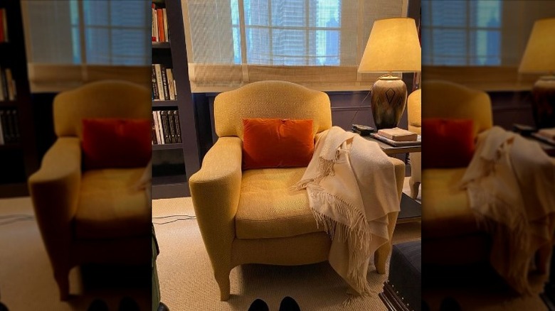 An armchair with blanket draped over an arm 