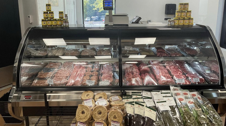 The deli counter at Avella's & Melilli's market with a variety of meats, canned goods, and dried herbs