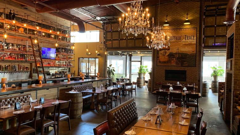 The interior of Carson's with set tables, chandeliers, and a bar