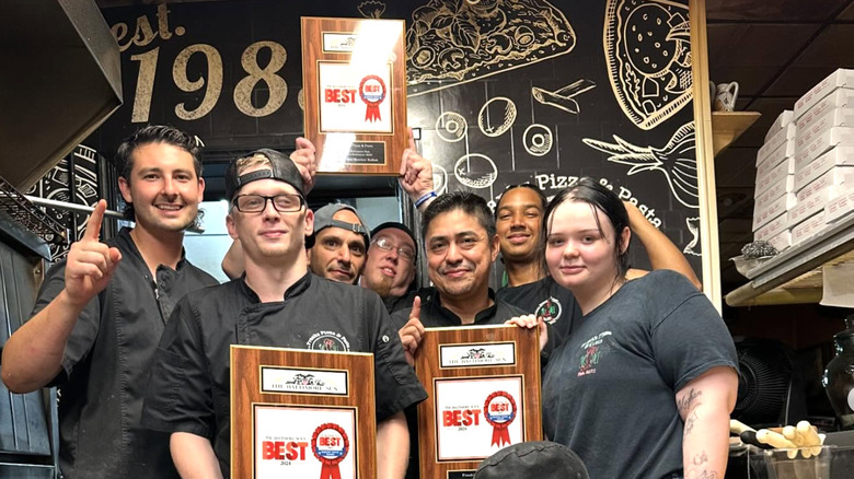 The team of Frank's Pizza holding a plaque