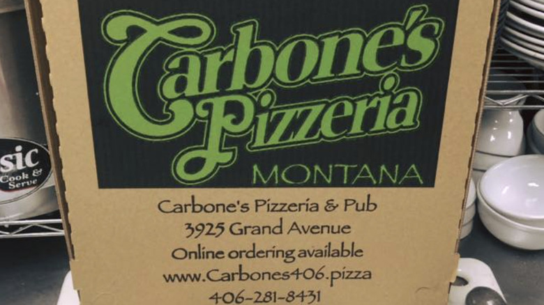 A pizza box with the Carbone's logo and contact information