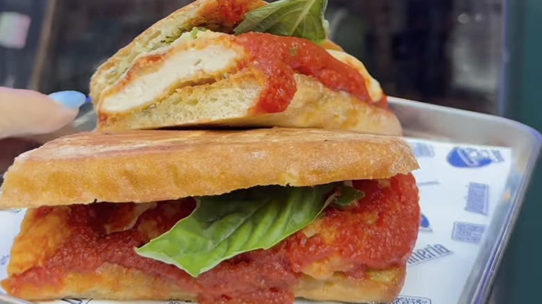 Panineria's chicken Parmesan sandwich cut in half on a tray