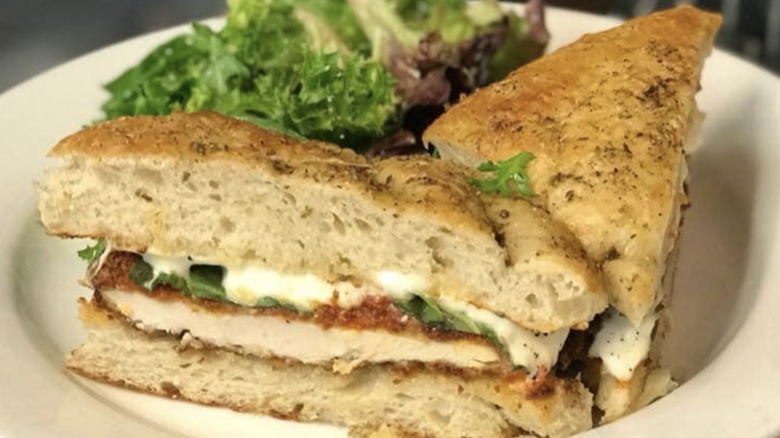The chicken Parmesan sandwich from Wheat Penny Oven and bar plated with a salad