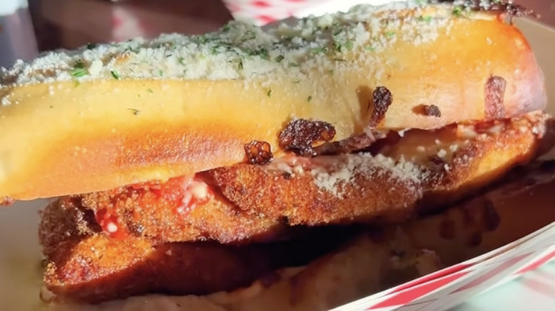 A full chicken Parmesan sub with cheese sprinkled on top