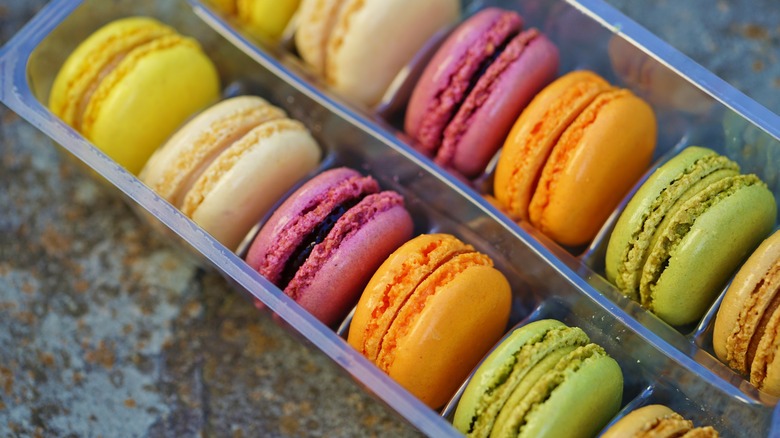 A plastic container with colorful macarons 