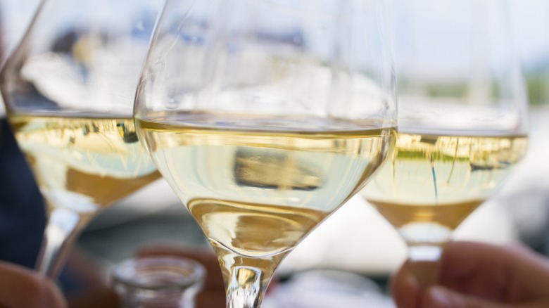 A close-up of three glasses of white wine