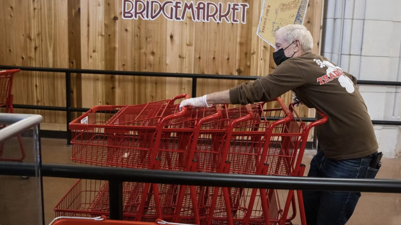 Trader Joe's worker stacking shopping carts