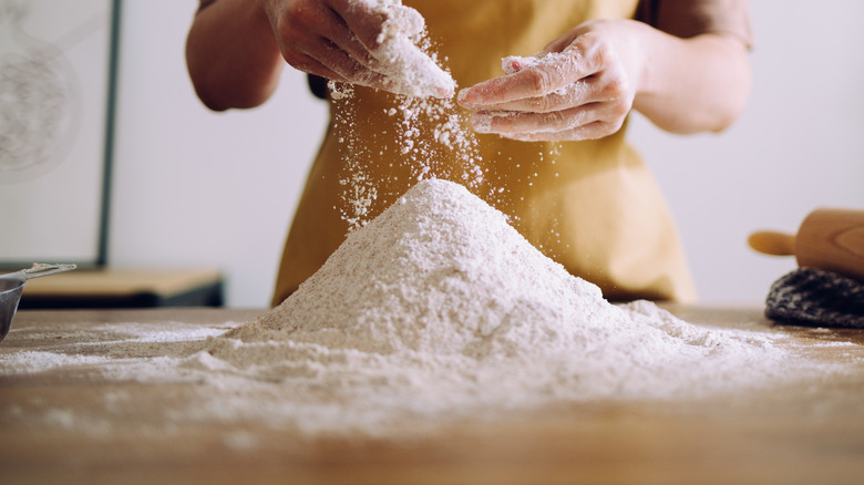 Person sprinkling flour