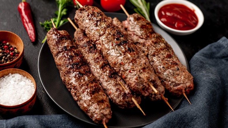 kebab meat on skewers on serving plate