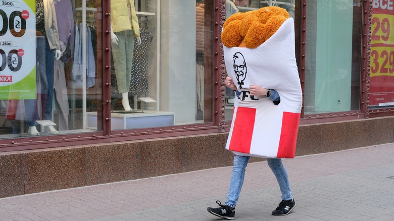 dejected KFC bucket walking down the streeet