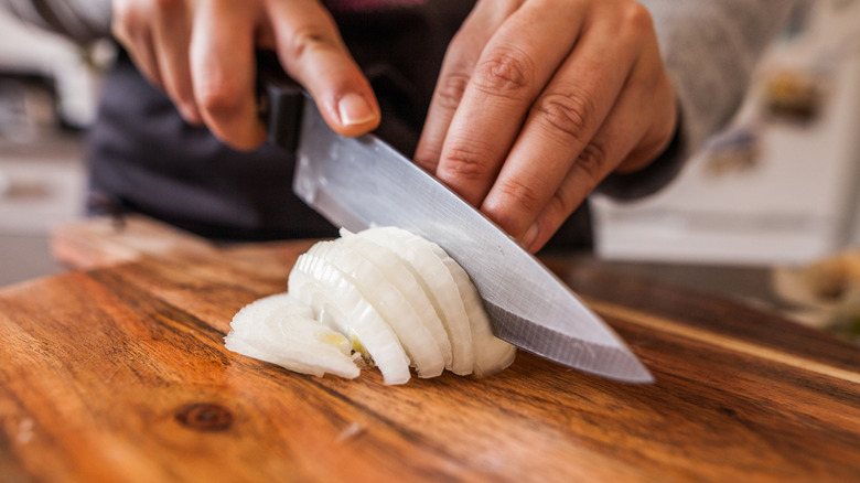Hands cutting onion