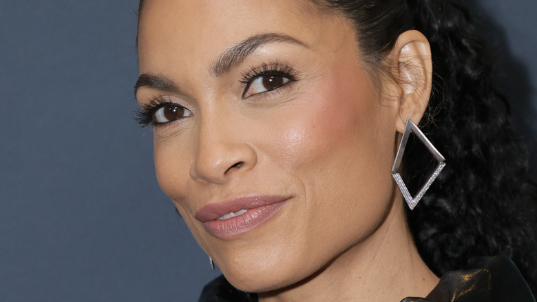 Rosario Dawson smiles with ponytail in close-up