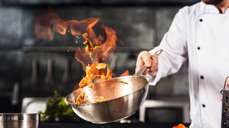 Chef tossing food in fire