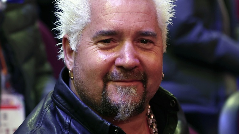 Guy Fieri smiles with gold earrings