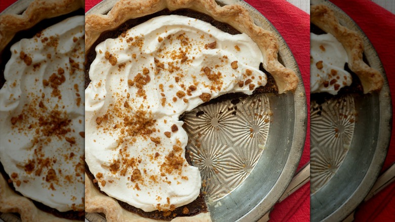 chocolate pie in a pan with whipped cream and crumbled graham topping