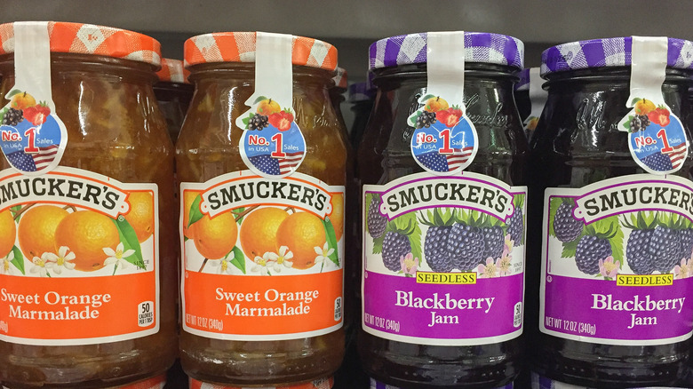 Jars of orange and purple Smuckers jams.