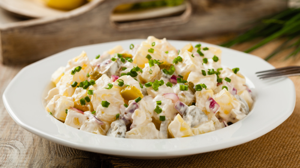 Creamy potato salad with chive garnish