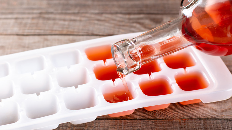 wine being poured into ice cube tray