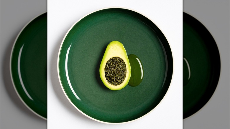 Tonburi dish in the shape of an avocado from Eleven Madison Park, served on a green ceramic plate