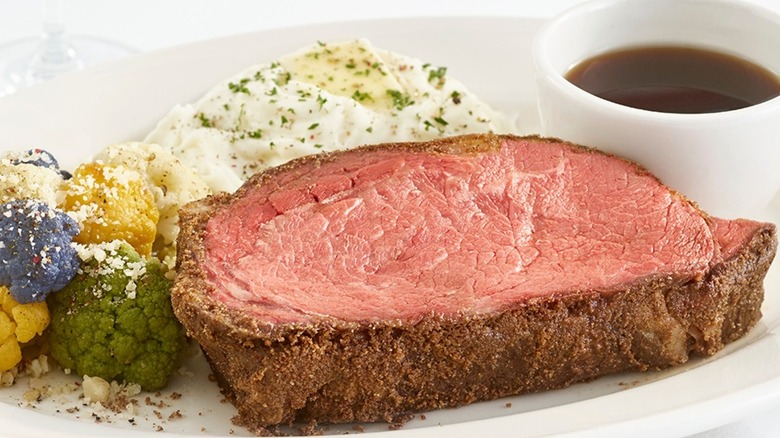J. Alexander's plate of prime rib with colorful cauliflower, mashed potatoes, and au jus