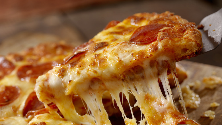 Slice of pepperoni pizza being served