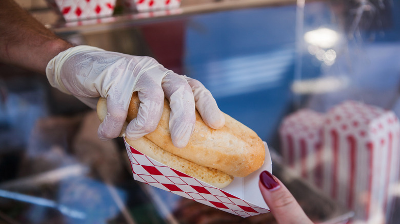 vendor passing hot dog to customer