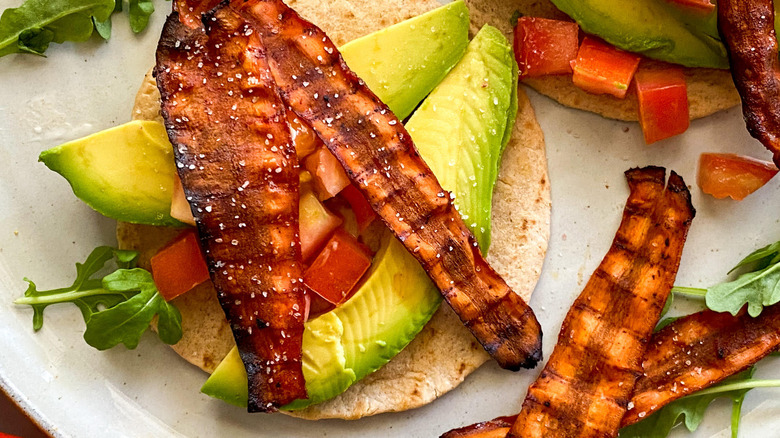Carrot bacon strips on avocado wrap