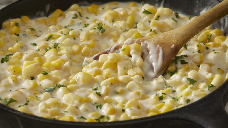 Creamed corn with wooden spoon
