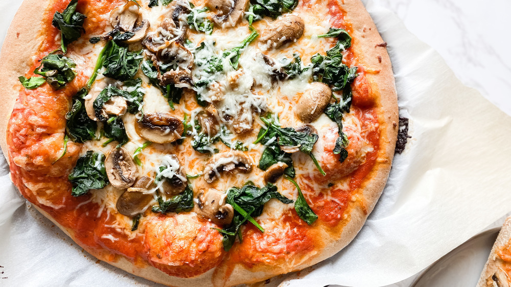 Pizza salutare con funghi, spinaci e crosta di grano integrale