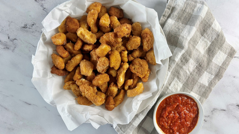 Cheese curds in bowl next to marinara sauce